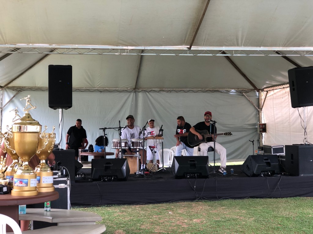 #ParaTodosVerem: Uma banda em cima de um palco tocando instrumentos.